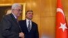 Turkey's President Abdullah Gul (background) and Palestinian President Mahmoud Abbas (L) walk, at Ataturk Airport in Istanbul, July 18, 2014.
