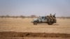 FILE - Burkina Faso soldiers patrol atop a pick-up truck on the road between Dori and Goudebo, in Burkina Faso, Feb. 3, 2020. 