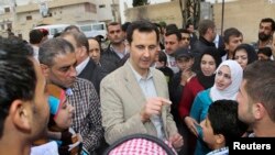 Syrian President Bashar al-Assad chats with people during his visit to Ein al-Tinah village, northeast of Damascus, April 20, 2014.