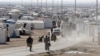 Syrian refugees walk at the Al Zaatari refugee camp in the Jordanian city of Mafraq, near the border with Syria, December 7, 2014.