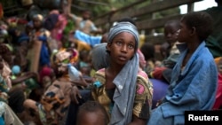 Girl sits at the back of a truck as she prepares to flee sectarian violence with other Muslim families in a convoy escorted by AU peacekeepers toward the border with Cameroon, Bouar, Central African Republic, March 9, 2014.