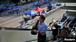 2014年10月6日政府工作人员上班。政府总部大楼外的示威者抗议继续。