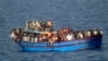 File - A boat overcrowded with migrants is pictured in the Mediterranean Sea. The bodies of some 30 would-be migrants were found in the hold of a packed smugglers' boat making its way to Italy, In this photo released by the Italian Navy, June 29, 2014.