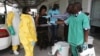 FILE - A health worker sprays a colleague with disinfectant during a training session for Congolese health workers to deal with Ebola virus in Kinshasa, Oct. 21, 2014. The process of removing the full-body protective suit is a prime opportunity for infection if the surface of the gear is contaminated.