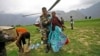 Indian army soldier helps an injured Indian pilgrim after she was rescued from the higher reaches of mountains, at a makeshift helipad at Joshimath, in northern Indian state of Uttarakhand,June 24, 2013.