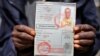An African migrant shows his ID at a detention center in Zawiya, northern Libya, May 27, 2014.