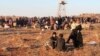 Syrian refugees, fleeing the violence in Syria, wait to enter Turkey on the Syrian-Turkish border in Shamm Alqrain village, northern countryside of Aleppo, Feb. 5, 2014.