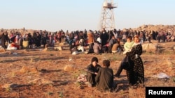 Syrian refugees, fleeing the violence in Syria, wait to enter Turkey on the Syrian-Turkish border in Shamm Alqrain village, northern countryside of Aleppo, Feb. 5, 2014.