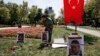 A man tends to a makeshift memorial for the victims of clashes between protesters and riot police at the Gezi Park in Istanbul, Turkey, July 12, 2013.