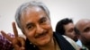 FILE - In this Friday, March 18, 2011 file photo, then Libyan senior Rebel commander Khalifa Hifter leaves a press conference in the court house in the center of Benghazi, eastern Libya.