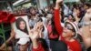 Supporters of Thailand's former Prime Minister Yingluck Shinawatra dance outside the Supreme Court after Yingluck failed to show up to hear a verdict in Bangkok Thailand, Aug. 25, 2017.