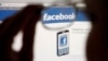 FILE - Facebook logo on a computer screen is seen through glasses held by a woman, May 19, 2012.