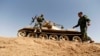 Members of Kurdish Peshmerga forces hold their position on June 21, 2014, in the Iraqi village of Basheer, 15 kilometers south of the city of Kirkuk, overlooking locations under Sunni militants led by the Islamic State of Iraq and the Levant (ISIL). 