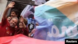 FILE - Brazil's President Dilma Rousseff (R) and her predecessor, Luiz Inacio Lula da Silva, wave to supporters during a campaign rally in Sao Paulo, Oct. 3, 2014. 