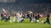 Besiktas fans throw plastic chairs onto the pitch during the Turkish Super League derby soccer match between Besiktas and Galatasaray at Ataturk Olympic Stadium in Istanbul late Sept. 22, 2013. 