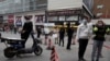 Residents wearing masks to protect against the spread of the coronavirus line up to enter a supermarket in Wuhan in central China's Hubei province on Friday, April 3, 2020. Chinese leaders are trying to revive the economy, but local officials under…