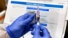 FILE - Nurse Kathe Olmstead prepares a shot as the world's biggest study of a possible COVID-19 vaccine, developed by the National Institutes of Health and Moderna Inc., gets underway, July 27, 2020, in Binghamton, N.Y. 