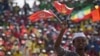 A youth waves the ruling party Ethiopian People’s Revolutionary Democratic Front (EPRDF) flag in front of a large crowd during an election rally by the EPRDF in Addis Ababa, May 21, 2015.