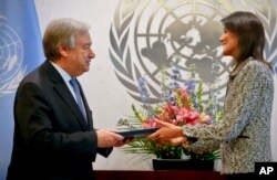 Former South Carolina Governor Nikki Haley, right, presents her credentials to United Nations Secretary General Antonio Guterres, left, as the new U.S. Ambassador to the United Nations at U.N. headquarters, Jan. 27, 2017.