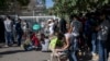 Migrants wait outside the government's Asylum Service to submit and provide documents for asylum claims, in Athens, June 11, 2020.