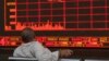 Un inversionista chino observa cómo el Índice Compuesto de Shanghai cae en una correduría en Beijing, el lunes 6 de mayo de 2019. El índice de referencia Compuesto de Shanghai de China se sumerge en la amenaza Trump de más aranceles de China.