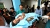FILE - Afghans help an injured man at a hospital after a suicide attack, in Kabul, Nov. 21, 2016. 