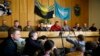 Vyacheslav Ponomaryov, the self-proclaimed mayor of Slovyansk, fourth from left, is flanked by a group of foreign military observers being held by Ponomaryov's group during a press conference in city hall, Slovyansk, eastern Ukraine, April 27, 2014.