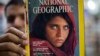 Pakistan's Inam Khan, owner of a book shop shows a copy of a magazine with the photograph of Afghan refugee woman Sharbat Gula, from his rare collection in Islamabad, Pakistan, Oct. 26, 2016. 