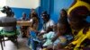 FILE - Women holding children wait for a medical examination at the health center in Gbangbegouine village, western Ivory Coast.