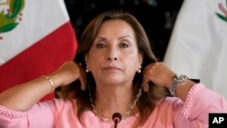 Presiden Peru Dina Boluarte menunjukkan perhiasan yang ia kenakan dalam konefrensi pers di Istana Pemerintahan di Lima, Peru, pada 5 April 2024. (Foto: AP/Martin Mejia)