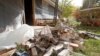 FILE - Chad Devereaux works to clear up bricks that fell from three sides of his in-laws' home in Sparks, Okla., after two earthquakes hit the area in less than 24 hours, April 6, 2011. 