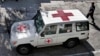 FILE - An Afghan policeman walks past a Red Cross vehicle in Jalalabad, east of Kabul, Afghanistan, May 30, 2013. Suspected Islamist militants reportedly killed six ICRC aid workers and abducted two others Wednesday after ambushing their convoy in northern Jowzjan province. 