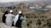 Men sit on the Nadir Khan hilltop overlooking Kabul, Afghanistan, March 27, 2017. American and Afghan officials are increasingly wary of the deepening ties between Russia and the Taliban that is fighting to topple the government in Kabul. 