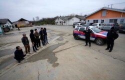 在塞尔维亚贝尔格莱德以北50公里的塞尔维亚北部城镇兹雷尼亚宁附近，在一家中国汽车轮胎工厂建筑工地打工的越南工人和塞尔维亚警察站在工房旁。（2021年11月18日）