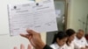 A member of the National Election Committee (NEC) and NEC's spokesman Dim Sovannarom shows a registration of political parties list to the media in Phnom Penh, Cambodia, April 30, 2018. 