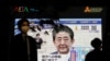 A pedestrian wearing a protective mask walks past a large screen on a building showing Japan's Prime Minister Shinzo Abe declaring a state of emergency, following the coronavirus disease (COVID-19) outbreak, in Tokyo, Japan April 7, 2020. REUTERS…
