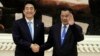 Cambodian Prime Minister Hun Sen, right, shakes hands with Japanese Prime Minister Shinzo Abe, left, as they pose for photos during a welcome ceremony in Peace Palace, in Phnom Penh, Cambodia, Saturday, Nov. 16, 2013. Abe is on a two-day official visit. (AP Photo/Heng Sinith)