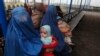 FILE - Afghan refugee women sit with their babies as they wait with others to be repatriated to Afghanistan, at the United Nations High Commissioner for Refugees (UNHCR) office on the outskirts of Peshawar, Feb. 2, 2015.