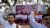 Myanmar nationalist Buddhist monks display placards as demonstrators shout slogans during a protest rally against a Thai court's verdict sentencing two Myanmar migrant workers to death, in Yangon, Myanmar, Dec. 29 2015.