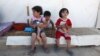 Syrian refugees children sit outside their tent at a Syrian refugee camp in the eastern town of Marj in Bekaa valley, Lebanon, June 29, 2014.