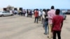 FILE - Migrants queue to receive food aid distributed by UNHCR amid the coronavirus pandemic, in Tripoli, Libya, May 12, 2020. The IOM has repatriated more than 100 Ghanaian migrants due to the ongoing conflict and virus spread in Libya. 