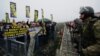 Paramilitary police stand as Fenerbahce fans shout slogans outside a Turkish court house in support of 93 suspects, including the club's jailed president Aziz Yildirim, ahead of the opening hearing of a match-fixing case in Silivri near Istanbul, Turkey, 