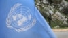 FILE - A United Nations peacekeeper is seen standing behind a U.N. flag.