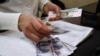 A cashier counts a pension payment in Russian roubles, in a post office at the Crimean city of Simferopol, March 25, 2014. 
