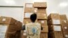 FILE - A World Food Program worker arranges relief packages at a warehouse designated to the United Nations for humanitarian aid for Africa, at the Bole International Airport in Addis Ababa, Ethiopia, April 14, 2020.