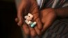 Nine-year-old Tumelo shows off antiretroviral (ARV) pills before taking his medication at Nkosi's Haven, south of Johannesburg, Nov. 28, 2014. 