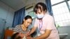 FILE - A child receives a vaccination shot at a hospital in Rongan in China's southern Guangxi region on July 23, 2018. 