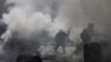 Civil defense members try to put out a fire at a site hit by what activists said was a barrel bomb dropped by forces loyal to Syria's President Bashar al-Assad in the Qadi Askar neighborhood of Aleppo, March 5, 2015. 