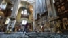 Seorang perempuan membersihkan puing-puing di dalam katedral yang rusak akibat serangan rudal Rusia di Zaporizhzhia, Ukraina 18 Oktober 2023. (REUTERS/Stringer)