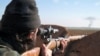 A militant fighter aims a sniper rifle during fighting in Tal Tamr, Hassakeh province, Syria, in this image posted by the Al-Baraka division of the Islamic State group, Feb. 24, 2015.